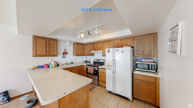 630 1100 West Provo, UT 84601 - Photo 45 of 64 Kitchen featuring extensive wood cabinetry, L-shaped countertop, tile flooring, and track lighting