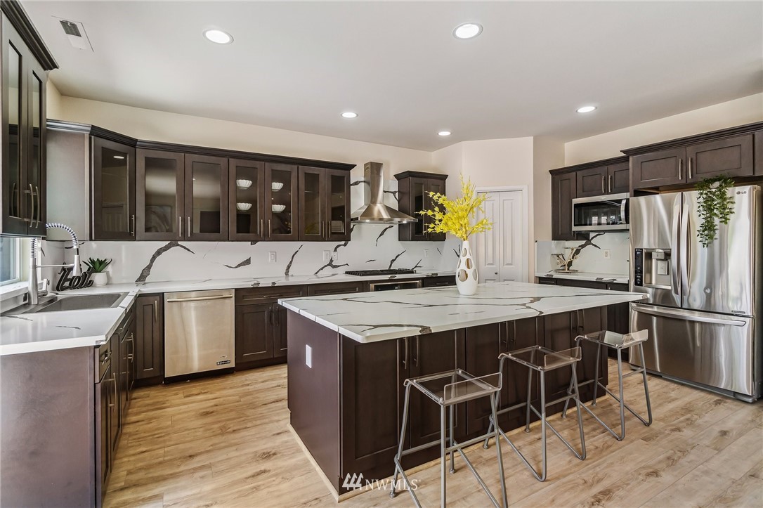4122 167th Place Southeast Bothell, WA 98012 - Photo 11 of 40 a kitchen with stainless steel appliances granite countertop a sink stove and refrigerator