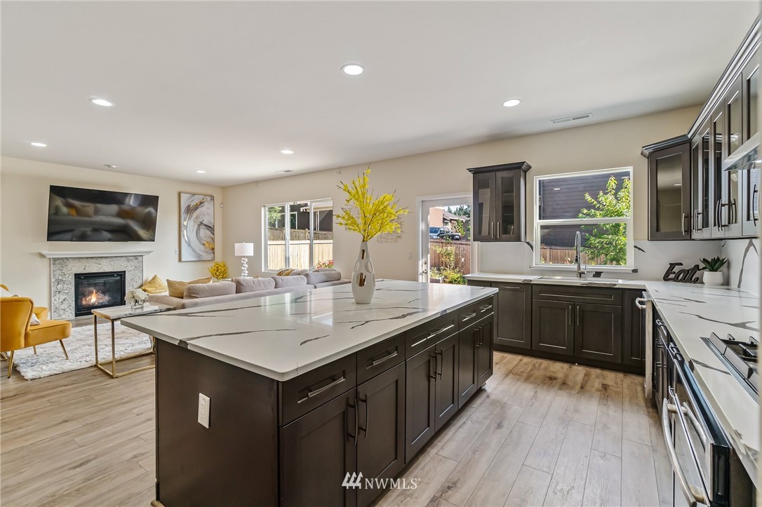 4122 167th Place Southeast Bothell, WA 98012 - Photo 13 of 40 a kitchen with a stove a sink a dining table and chairs