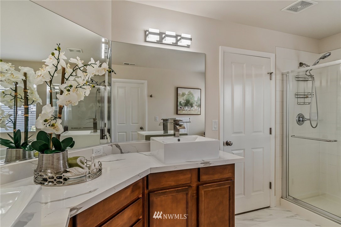 4122 167th Place Southeast Bothell, WA 98012 - Photo 28 of 40 a bathroom with a sink a mirror and a shower