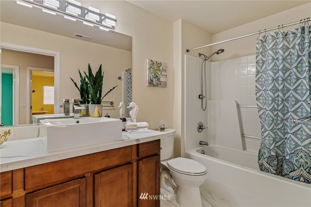 4122 167th Place Southeast Bothell, WA 98012 - Photo 35 of 40 a bathroom with a sink a toilet a mirror a vanity and shower