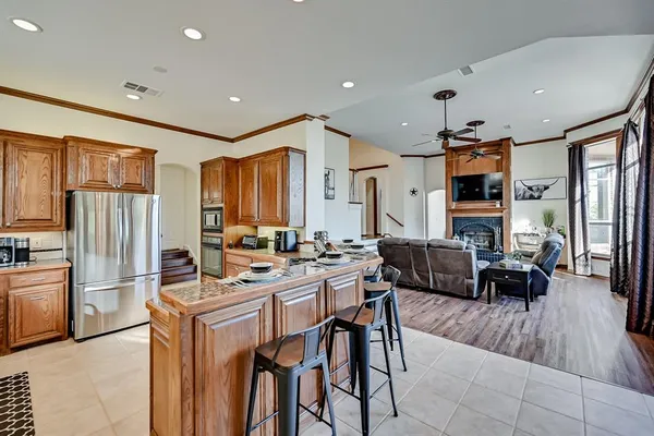 a kitchen with stainless steel appliances granite countertop a stove a sink dishwasher and cabinets with wooden floor