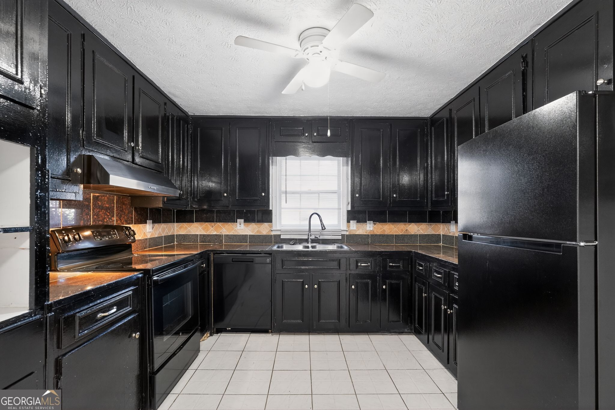 6581 Woodrow Road Lithonia, GA 30038 - Photo 15 of 34 a kitchen with a sink stainless steel appliances and cabinets