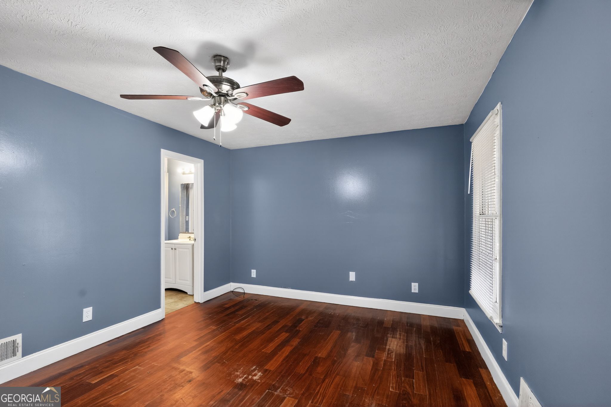 6581 Woodrow Road Lithonia, GA 30038 - Photo 19 of 34 an empty room with wooden floor and fan