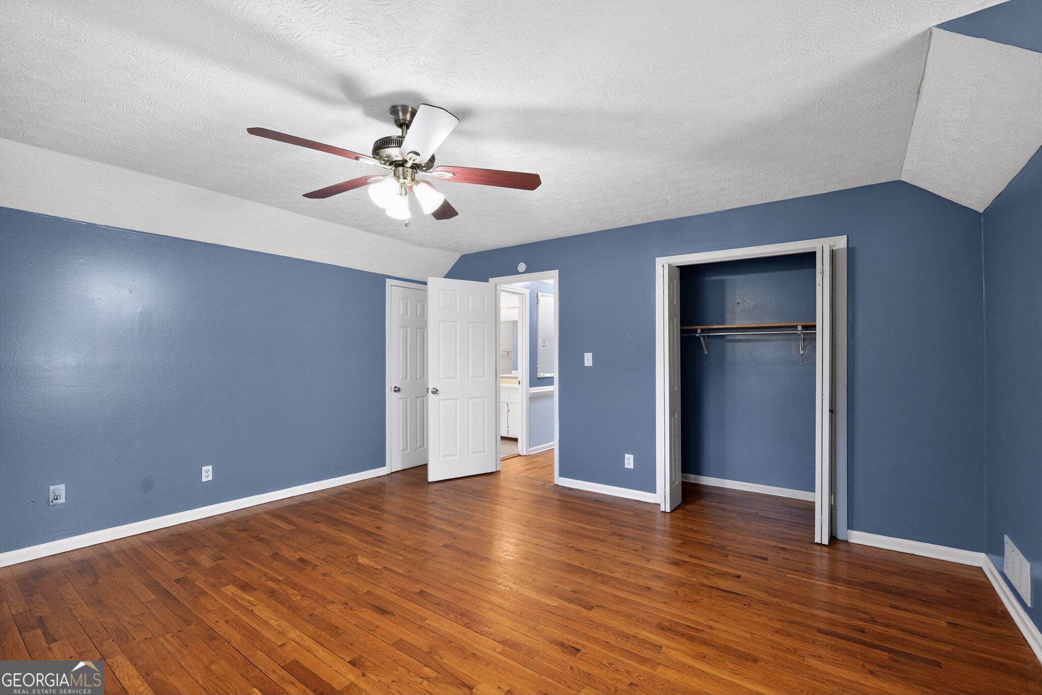 6581 Woodrow Road Lithonia, GA 30038 - Photo 22 of 34 a view of an empty room with wooden floor and a ceiling fan