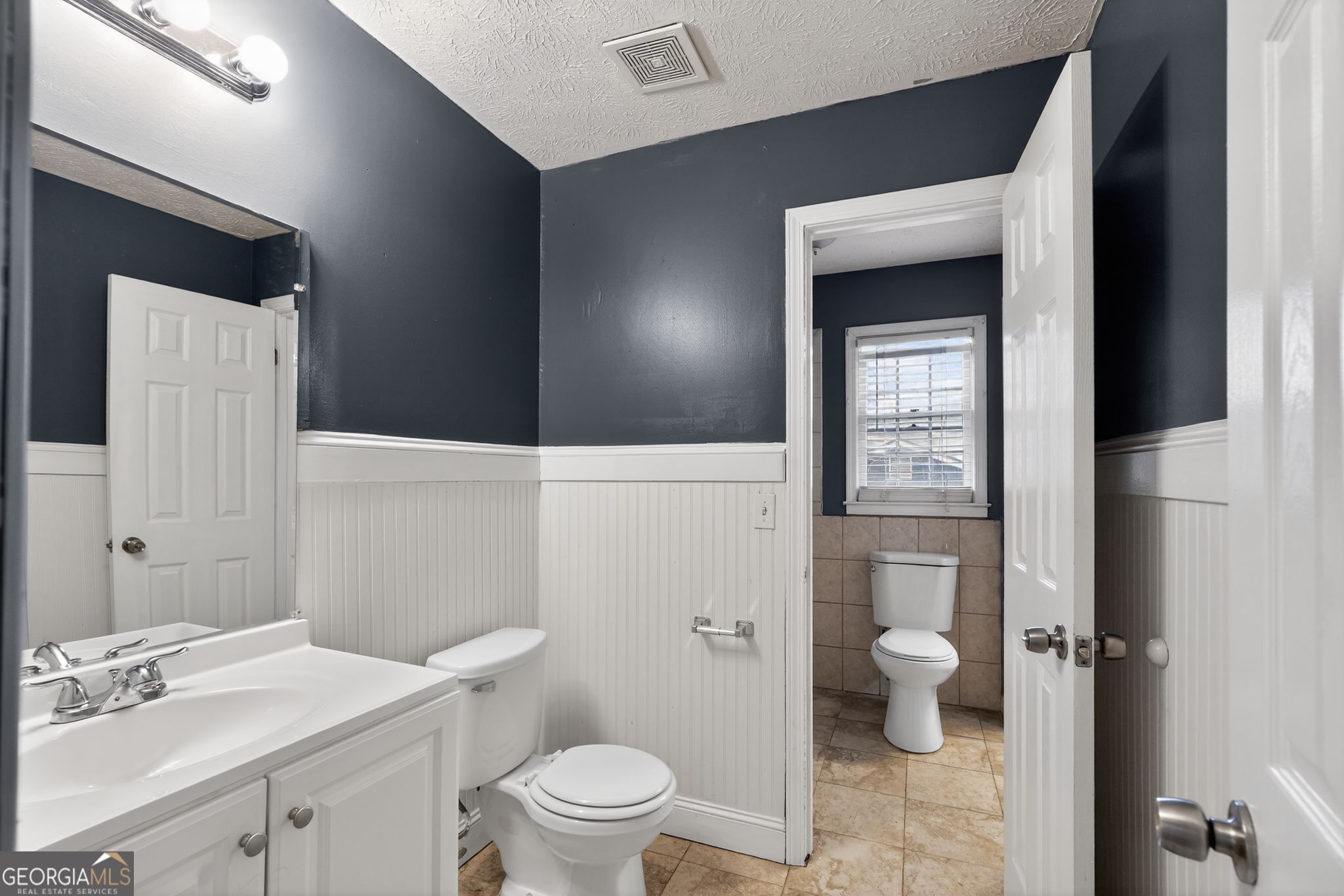 6581 Woodrow Road Lithonia, GA 30038 - Photo 23 of 34 a bathroom with a toilet a sink and mirror