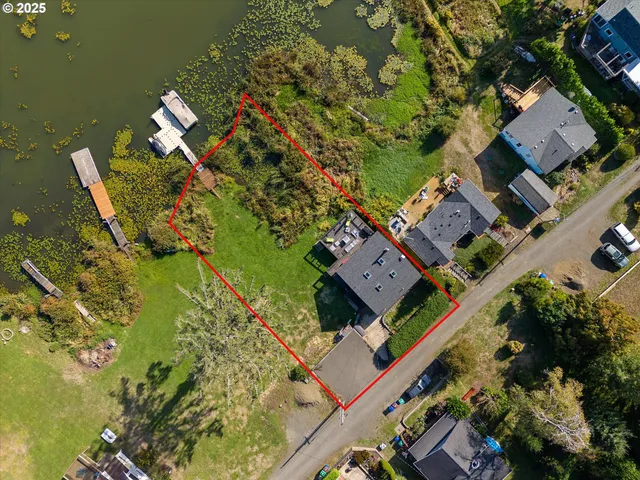 an aerial view of a house with a yard and lake view