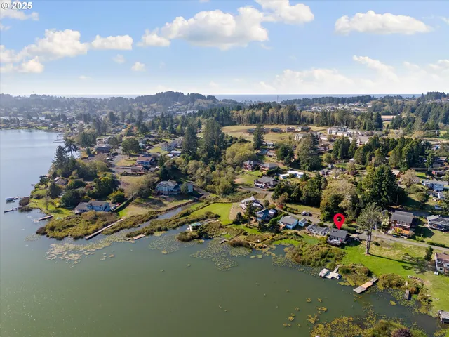 an aerial view of residential houses with outdoor space and lakeside