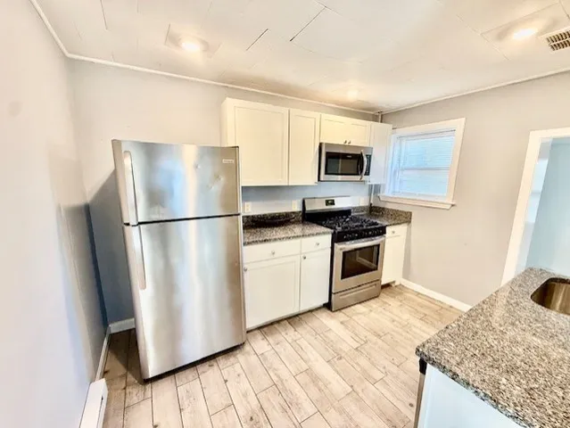 a kitchen with a refrigerator and a stove top oven