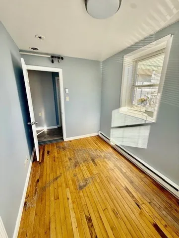a view of a bedroom with wooden floor and cabinet