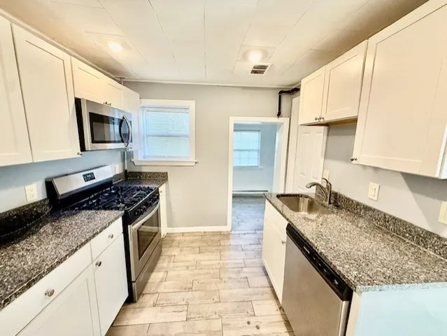 a kitchen with granite countertop a sink and a stove