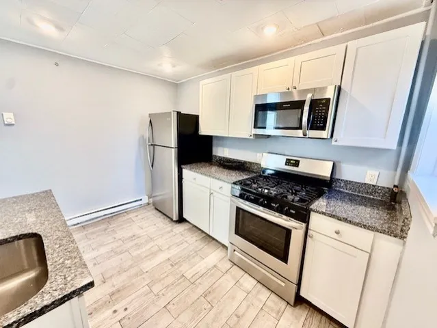 a kitchen with stainless steel appliances granite countertop a stove and a refrigerator