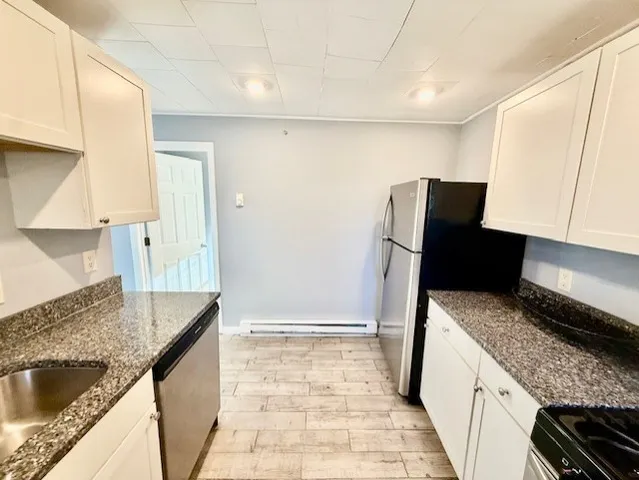 a kitchen with granite countertop a refrigerator and a sink