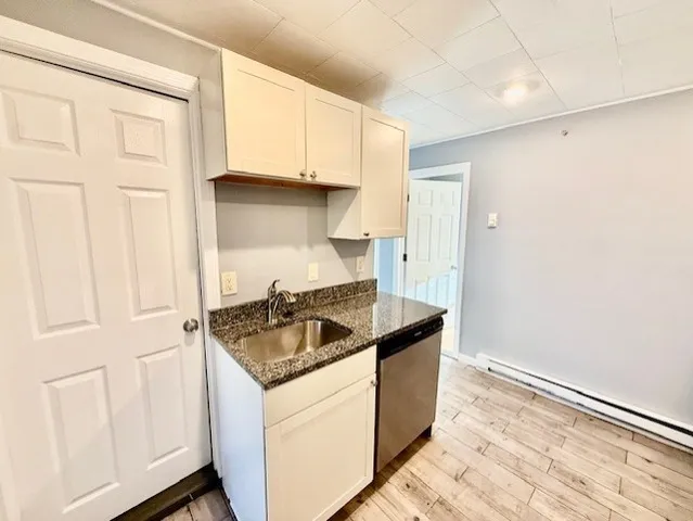 a kitchen with granite countertop white cabinets and a sink