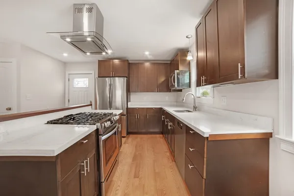 a kitchen with stainless steel appliances granite countertop a sink stove and refrigerator