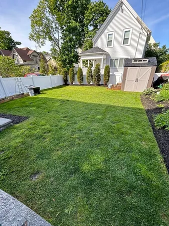 a view of a house with a big yard and large trees
