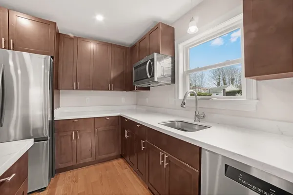 a kitchen with a sink refrigerator and microwave