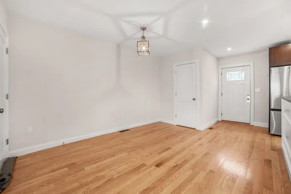 a view of empty room with wooden floor and ceiling fan