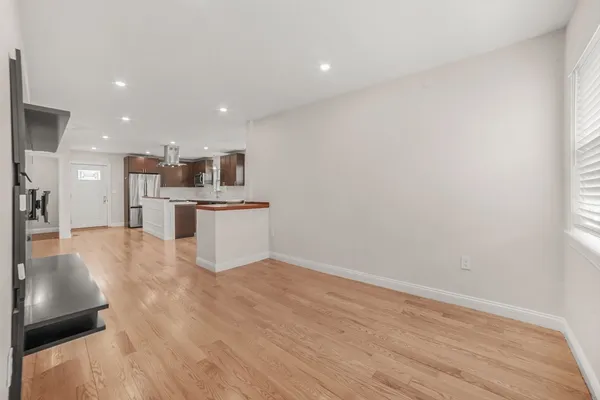 a view of kitchen with kitchen island granite countertop a sink and a stove top oven