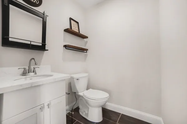 a bathroom with a toilet a sink and mirror