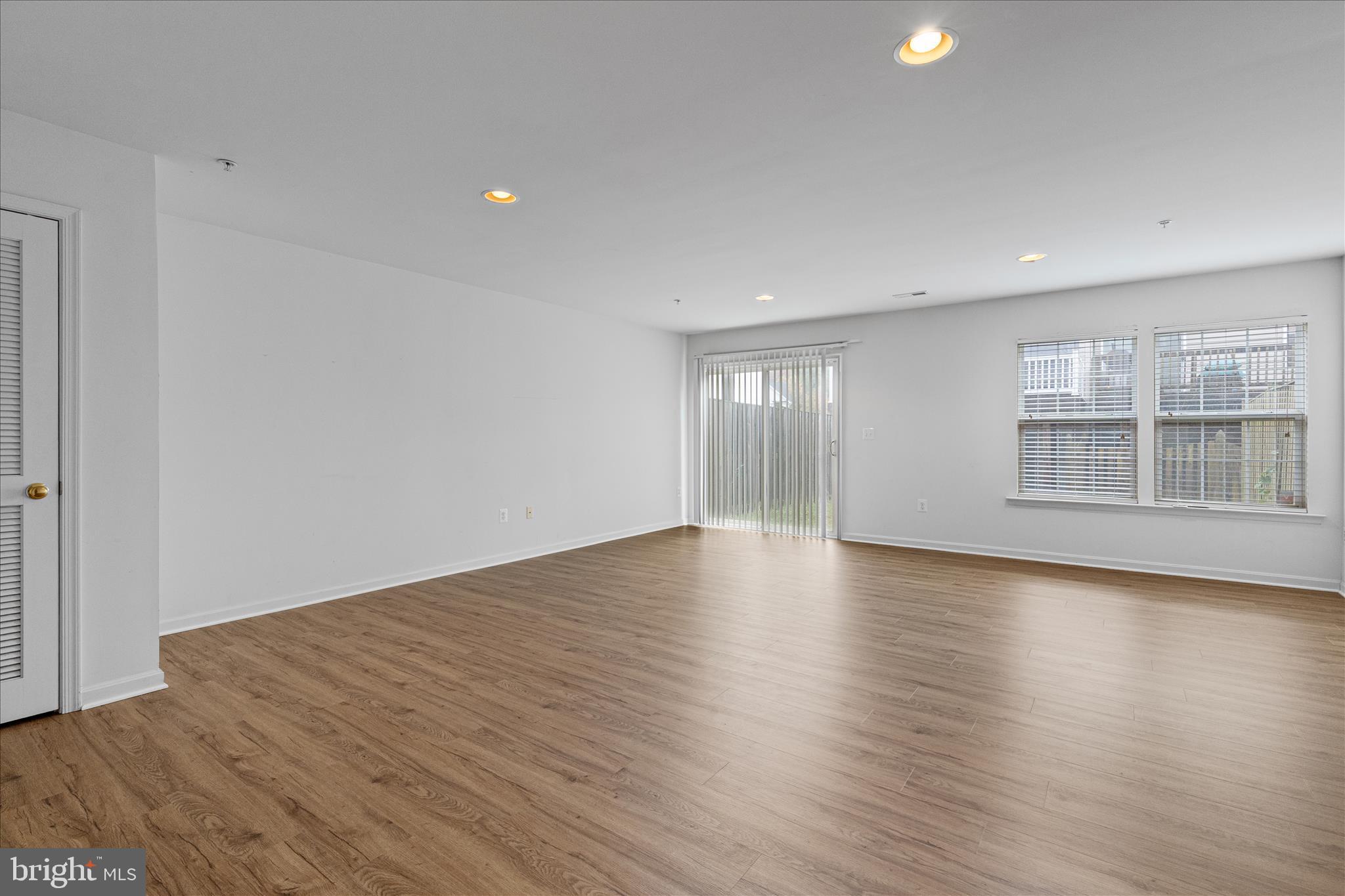 22742 Bayside Way California, MD 20619 - Photo 6 of 33 an empty room with wooden floor and windows