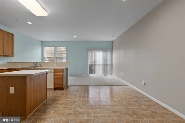 a large kitchen with granite countertop a sink a counter top space and cabinets