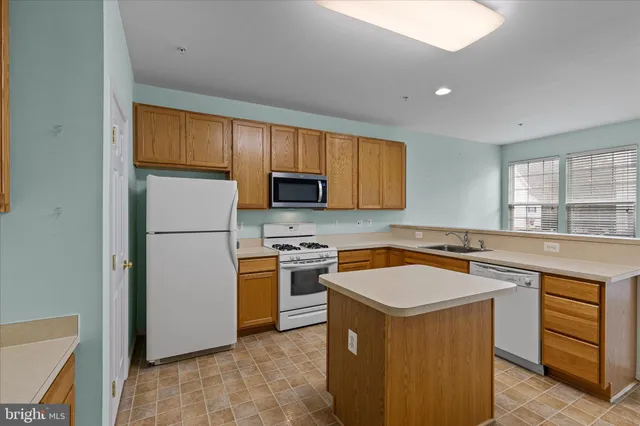 a kitchen with stainless steel appliances granite countertop a stove a sink dishwasher a refrigerator and a microwave