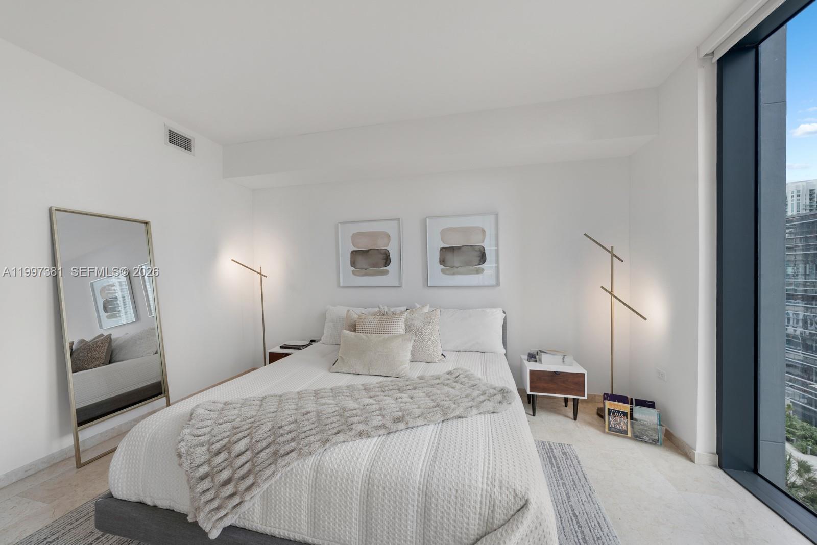 88 Southwest 7th Street, Unit 1401 Miami, FL 33130 - Photo 11 of 27 a bedroom with a bed and wooden floor