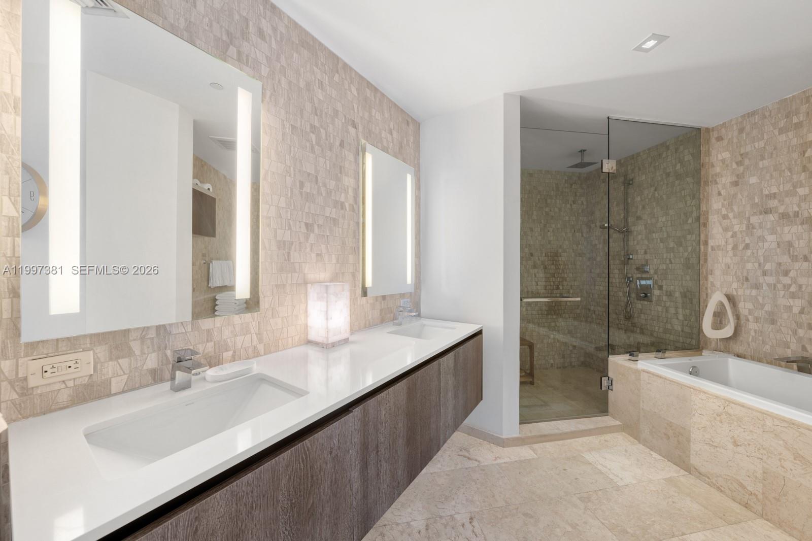 88 Southwest 7th Street, Unit 1401 Miami, FL 33130 - Photo 14 of 27 a bathroom with a granite countertop tub sink and mirror
