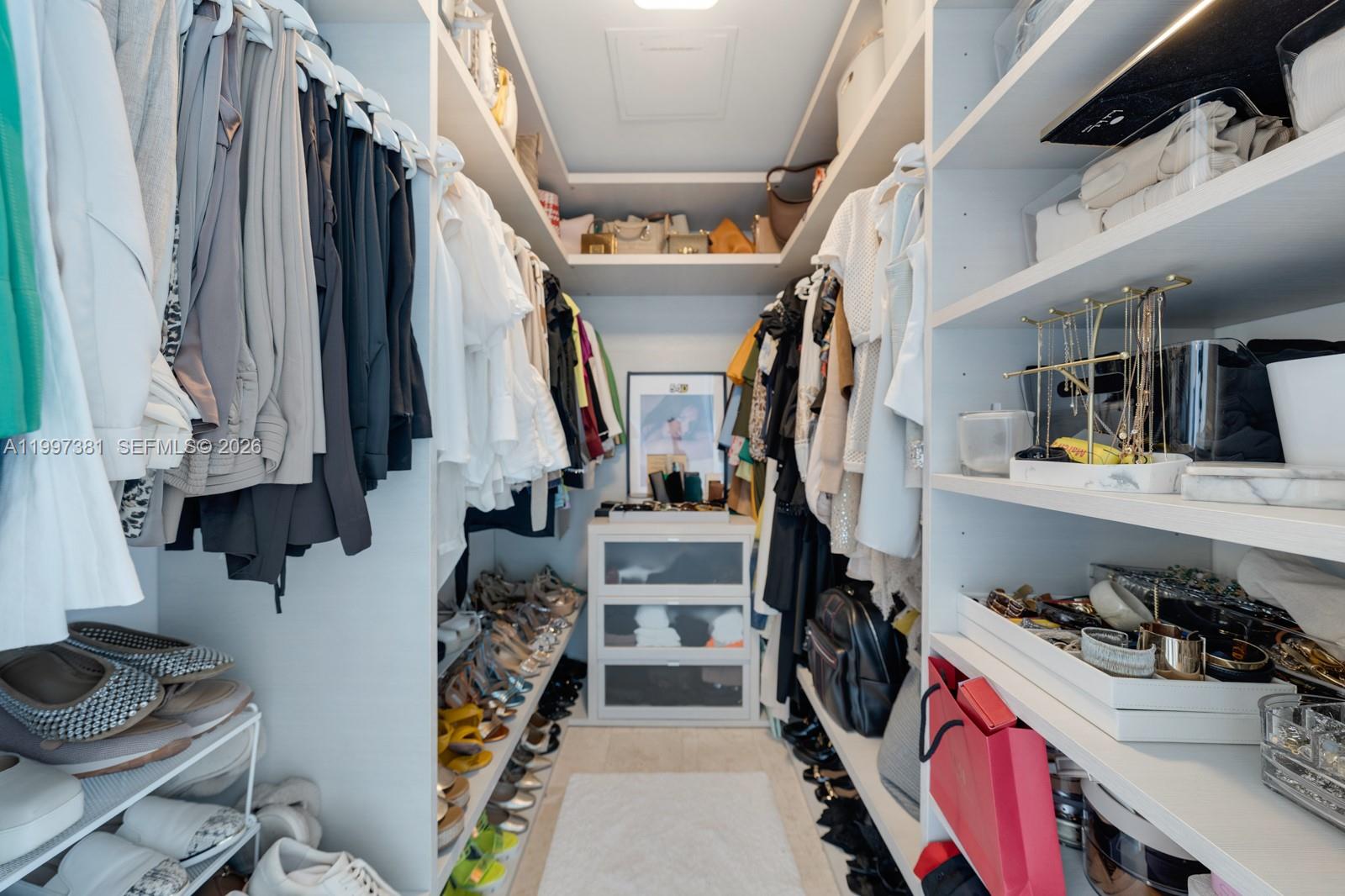 88 Southwest 7th Street, Unit 1401 Miami, FL 33130 - Photo 16 of 27 a view of walk in closet with clothes and shoes
