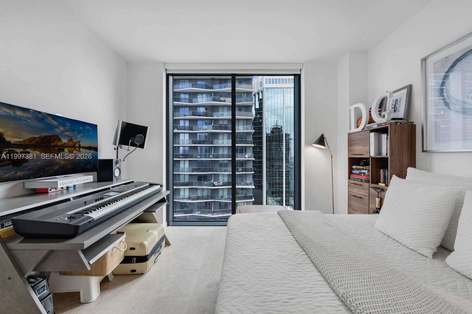 88 Southwest 7th Street, Unit 1401 Miami, FL 33130 - Photo 18 of 27 a bedroom with a bed and a flat screen tv