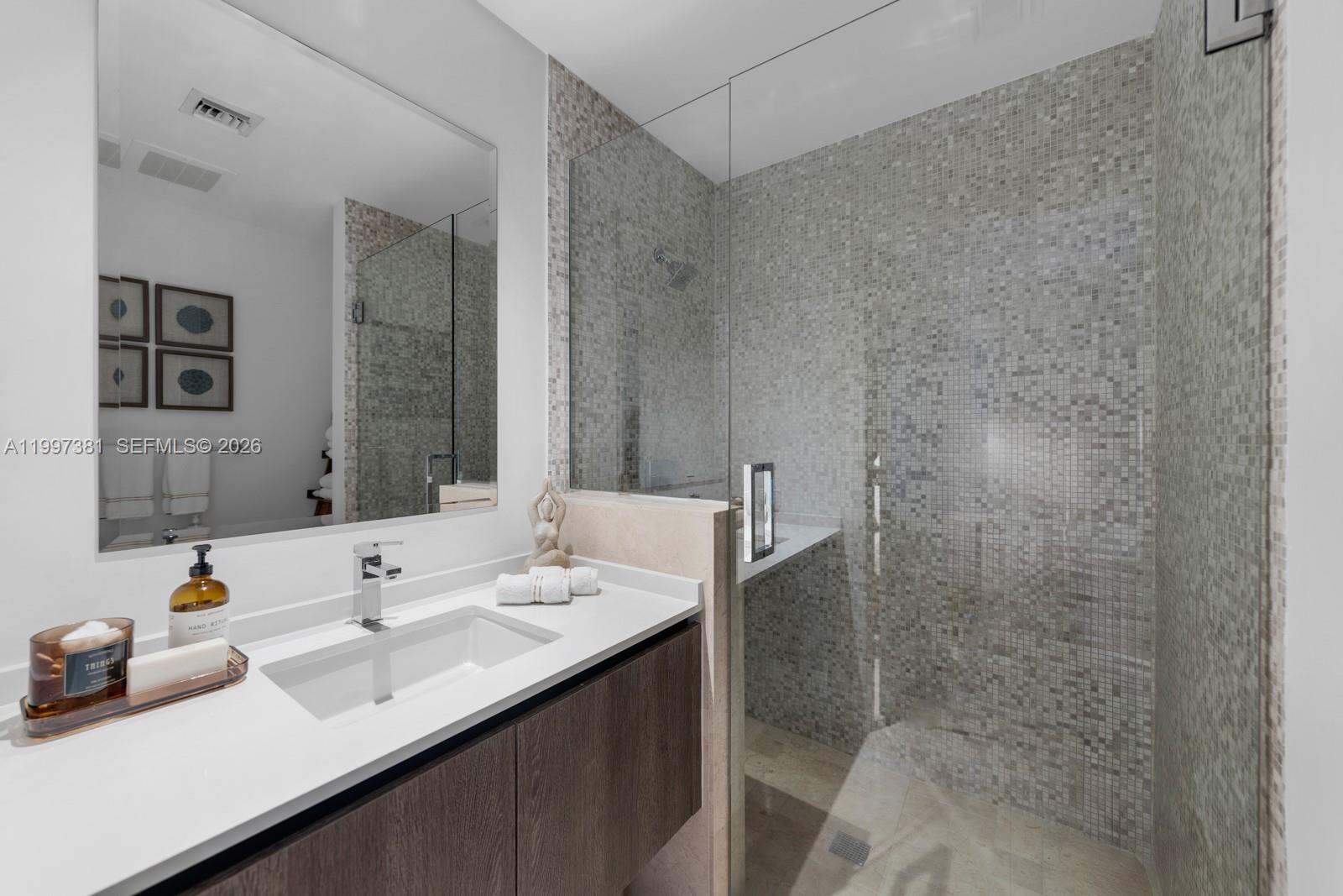 88 Southwest 7th Street, Unit 1401 Miami, FL 33130 - Photo 19 of 27 a bathroom with a sink and a mirror