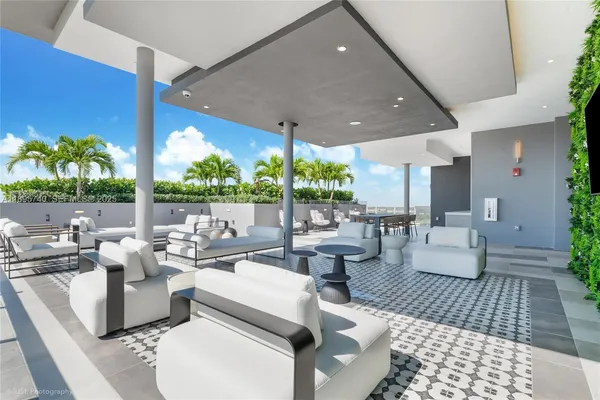 a living room with patio furniture and a potted plant