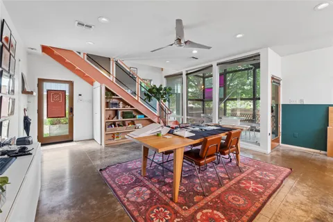 a living room with furniture a rug potted plant and a large window