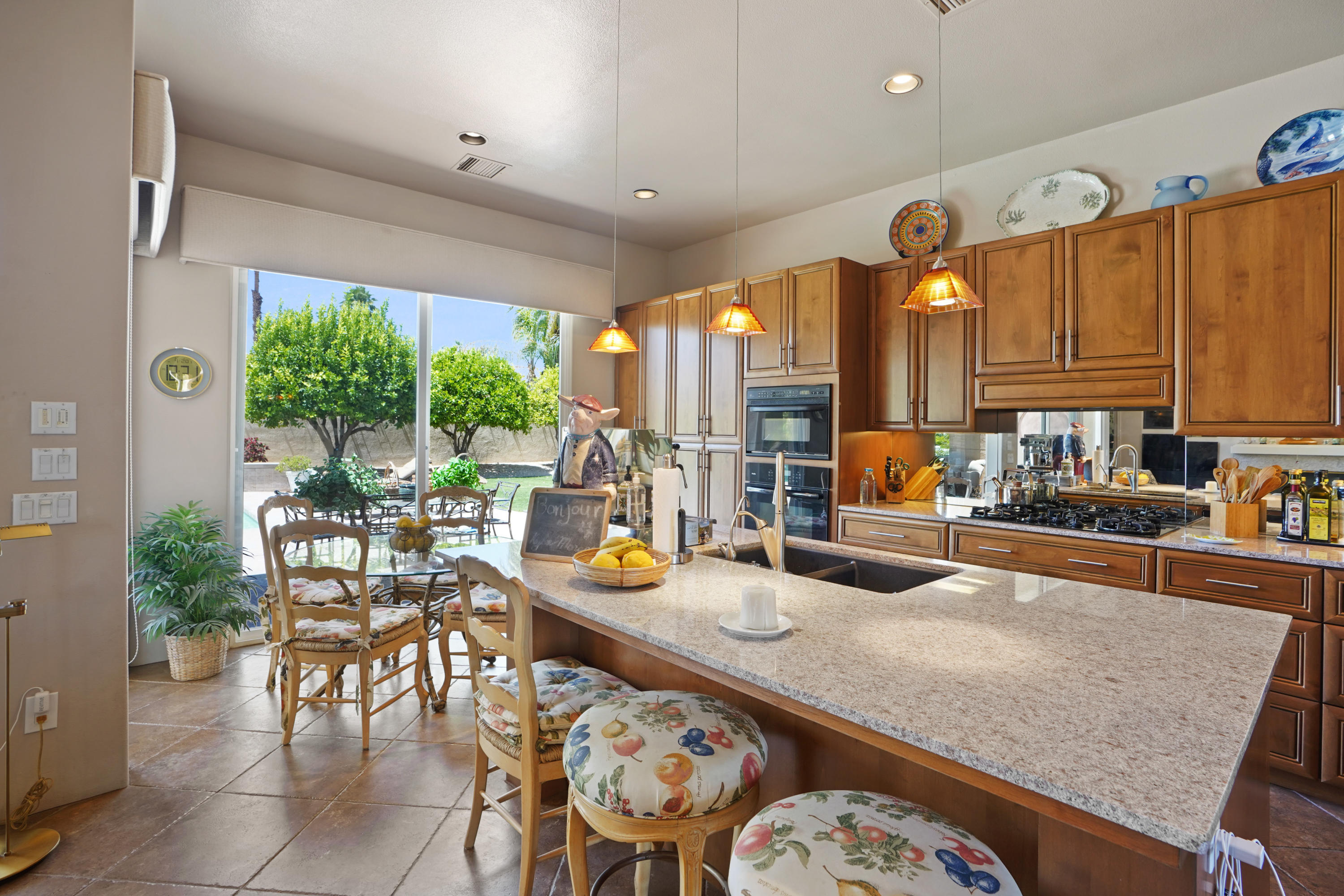 3 Silver Circle Rancho Mirage, CA 92270 - Photo 13 of 34 a kitchen with stainless steel appliances wooden floor dining table and chairs