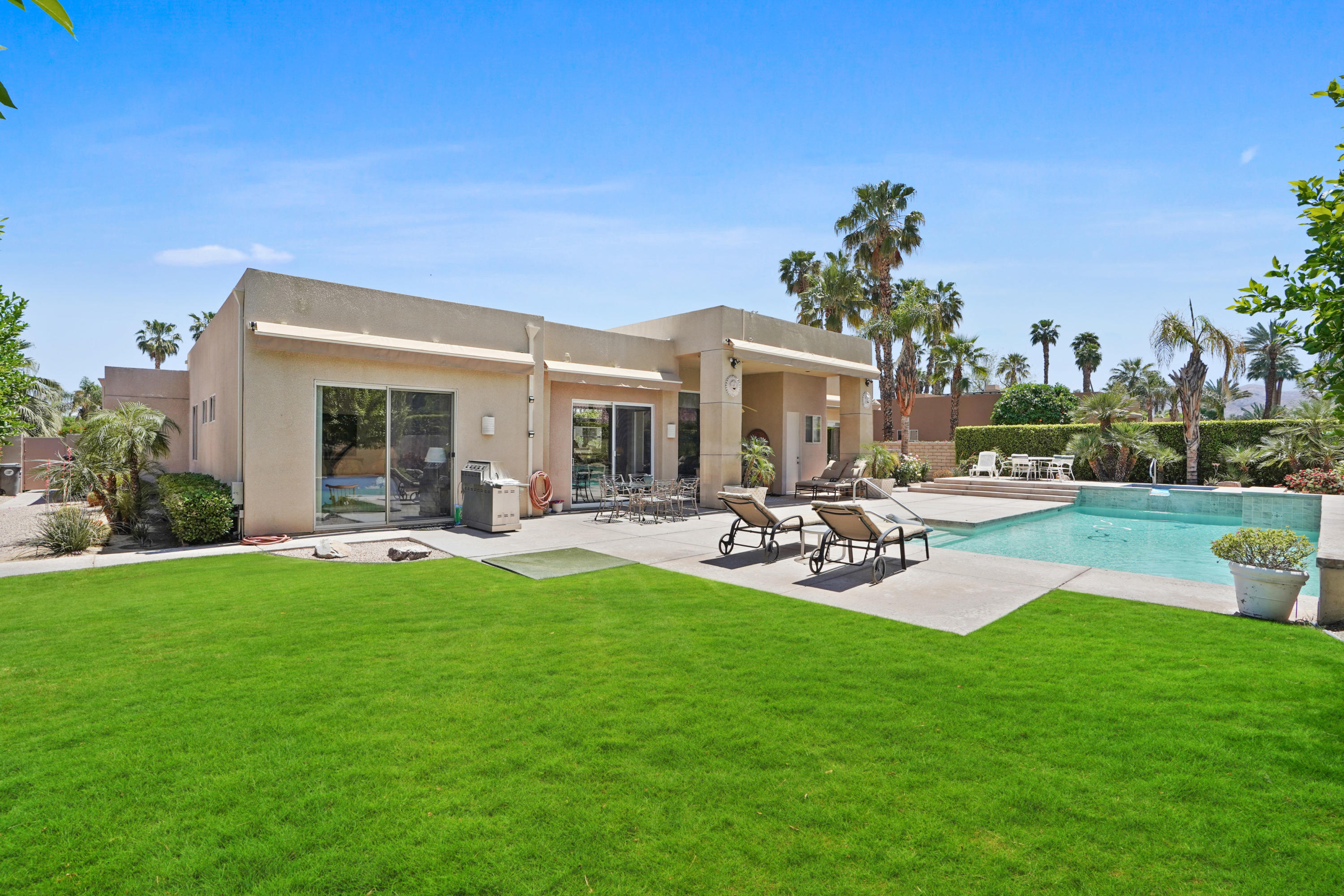 3 Silver Circle Rancho Mirage, CA 92270 - Photo 27 of 34 a view of a patio with couches and table and chairs with plants and big yard