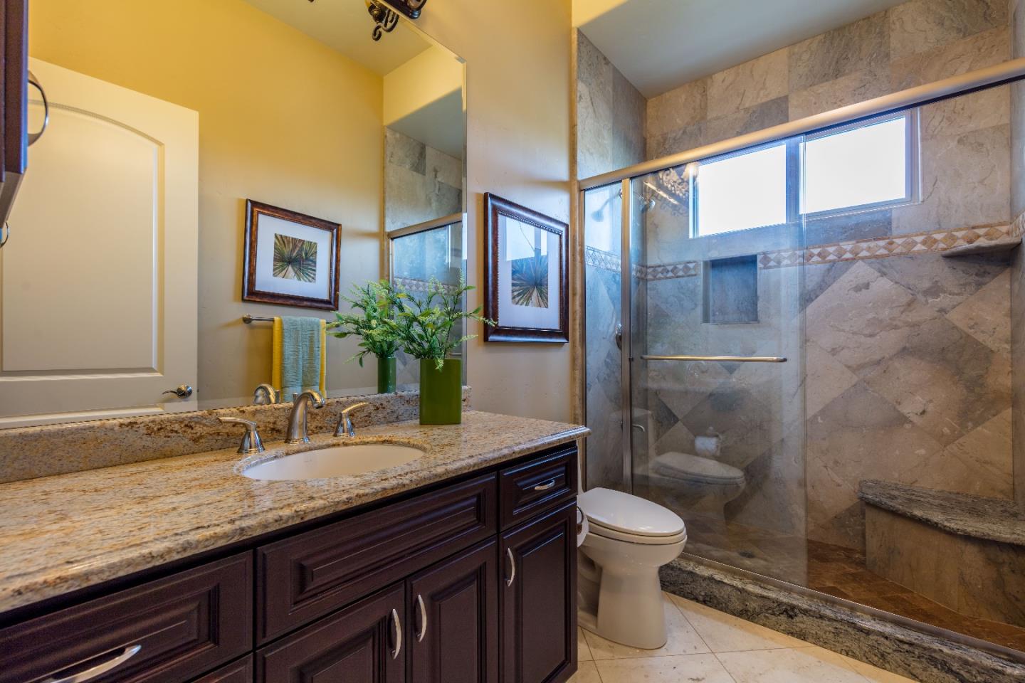 8715 Leavesley Road Gilroy, CA 95020 - Photo 21 of 50 a bathroom with a granite countertop sink toilet a mirror and shower