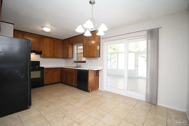 a kitchen with kitchen island granite countertop a sink a counter top space stainless steel appliances cabinets and a window