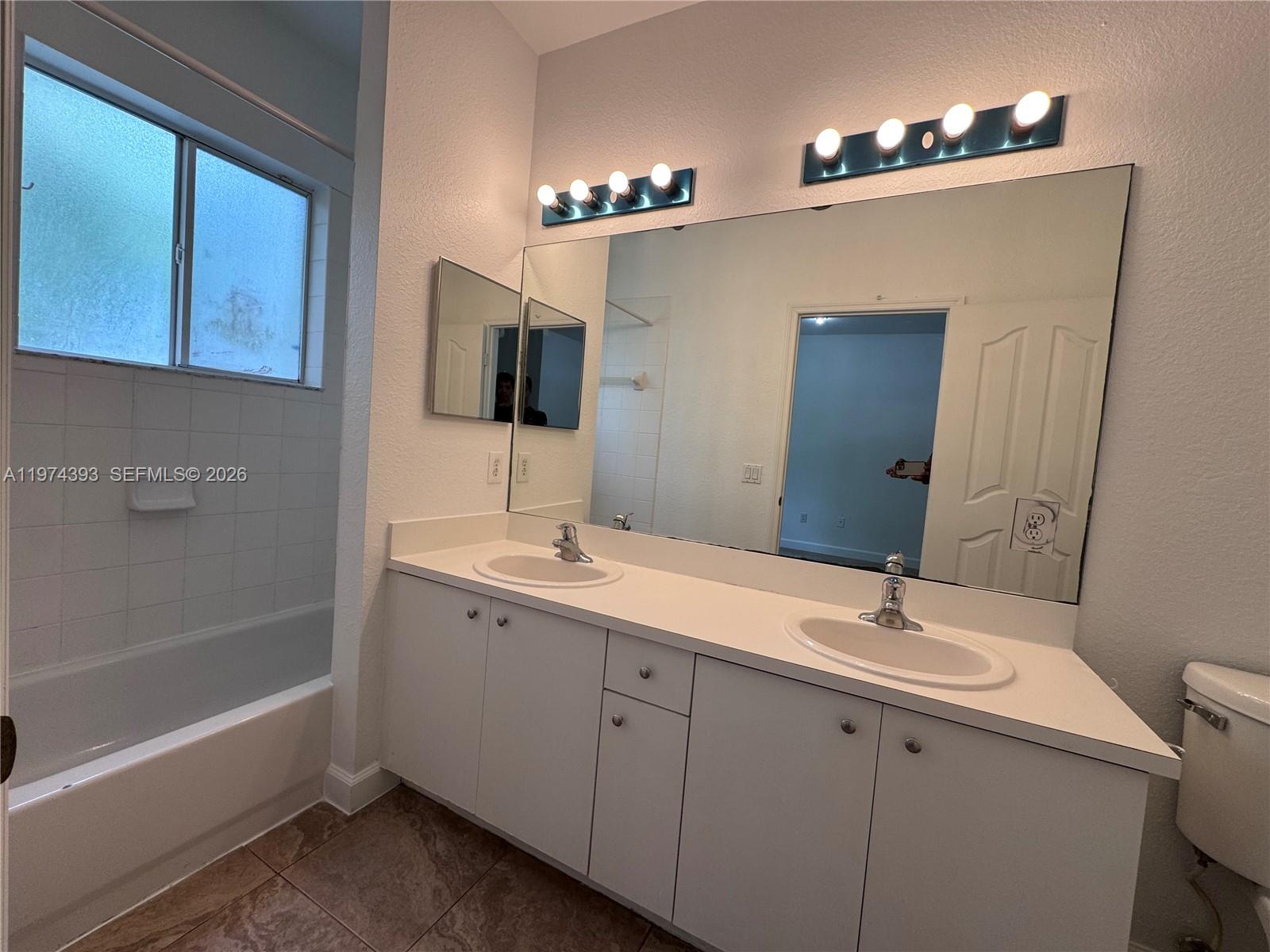 8500 Southwest 150th Avenue, Unit 3 Miami, FL 33193 - Photo 12 of 22 a bathroom with a sink double vanity granite tub and a mirror