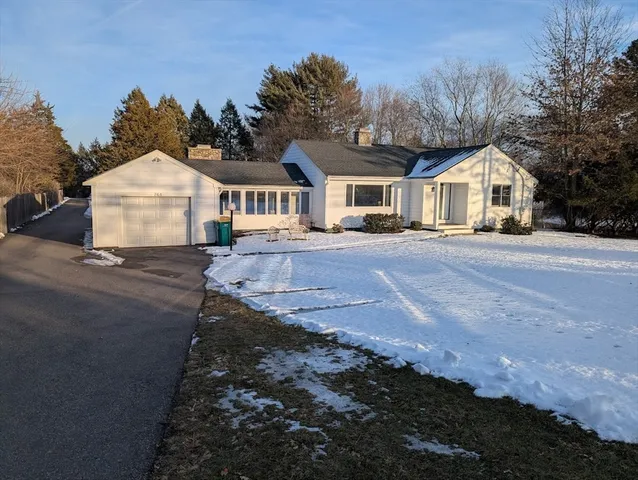 a front view of a house with a yard and trees