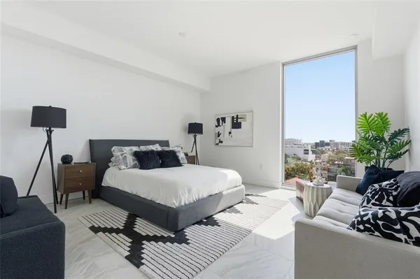 a bedroom with a bed couch and a potted plant