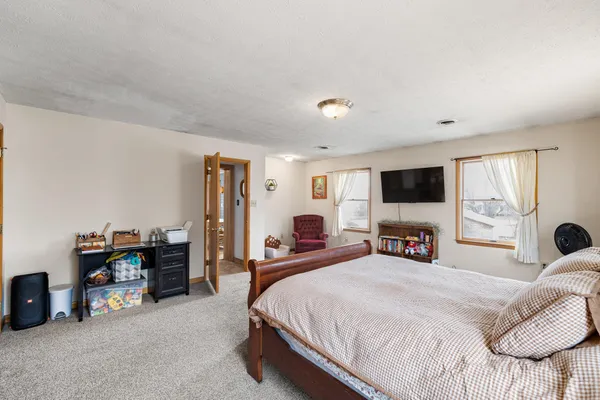 a bedroom with a bed and a flat tv screen