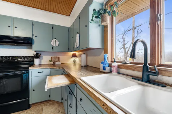 a kitchen with a stove a sink and cabinets