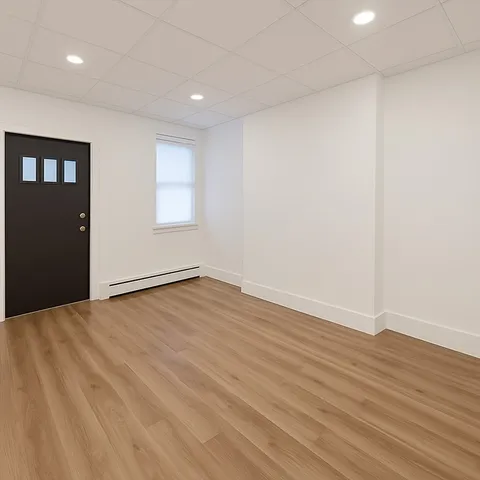 a view of an empty room with wooden floor