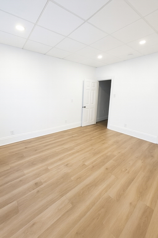 303 Princeton Street, Unit 1 Boston, MA 02128 - Photo 6 of 7 an empty room with wooden floor and windows