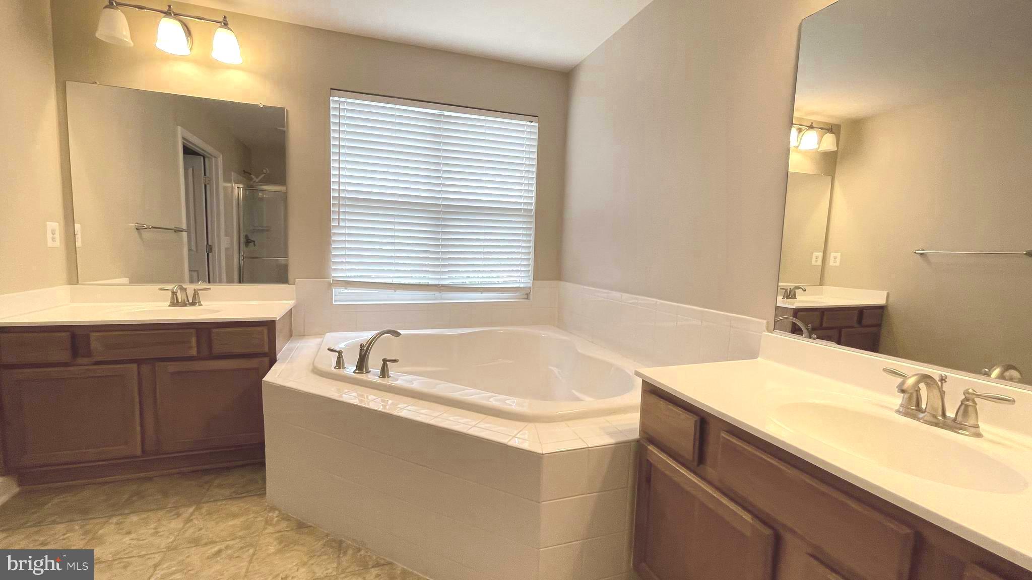 9008 Hanson Grove Court Manassas, VA 20109 - Photo 6 of 13 a bathroom with a granite countertop bathtub sink and mirror