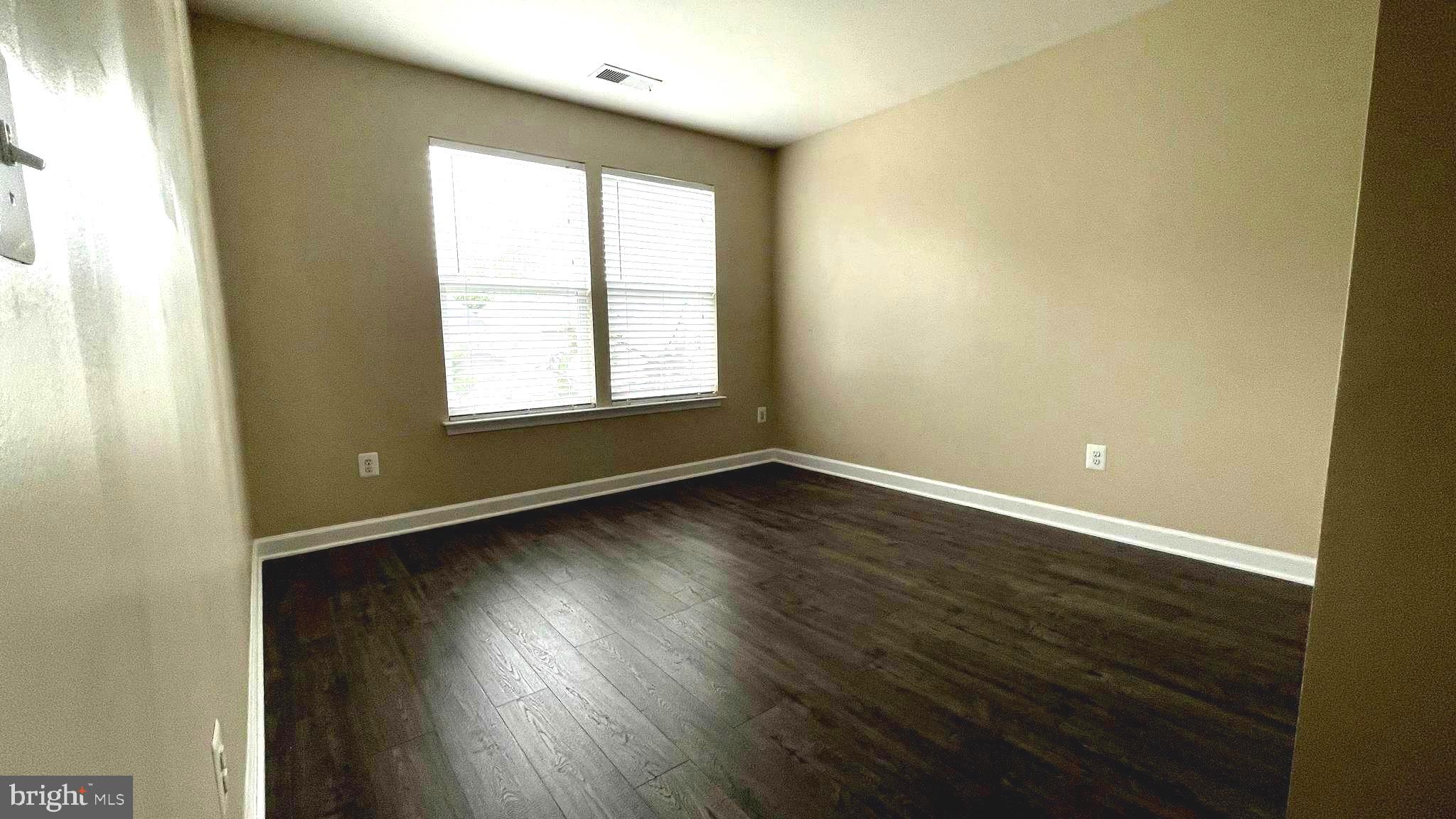 9008 Hanson Grove Court Manassas, VA 20109 - Photo 7 of 13 an empty room with wooden floor and windows
