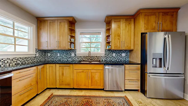 a kitchen with stainless steel appliances granite countertop a refrigerator and a sink
