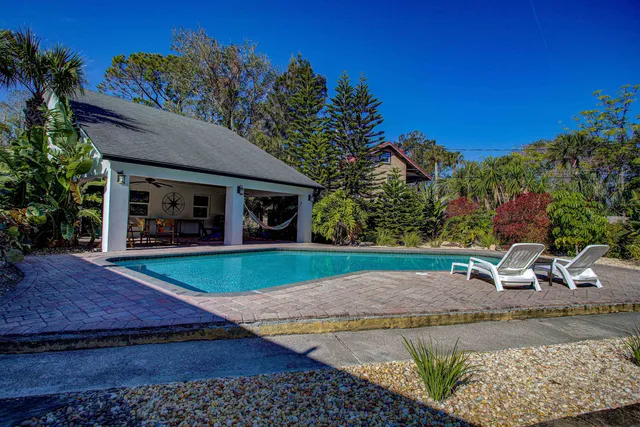 a view of a backyard with a fountain plants and large tree