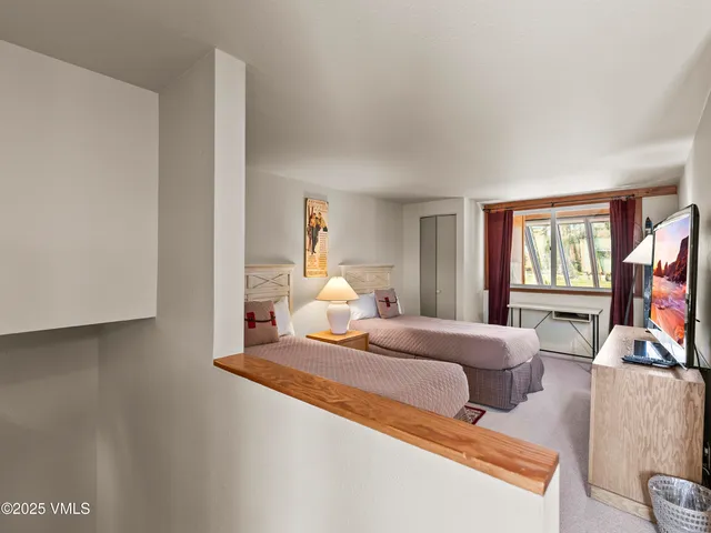 a bedroom with a bed wooden floor and window